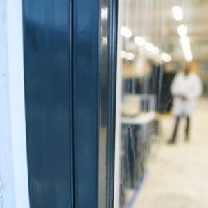 Detail van brandwerend kitwerk aan schuifdeuren in een industri&euml;le omgeving, benadrukt de toepassing van staalcoatings voor bescherming en duurzaamheid.