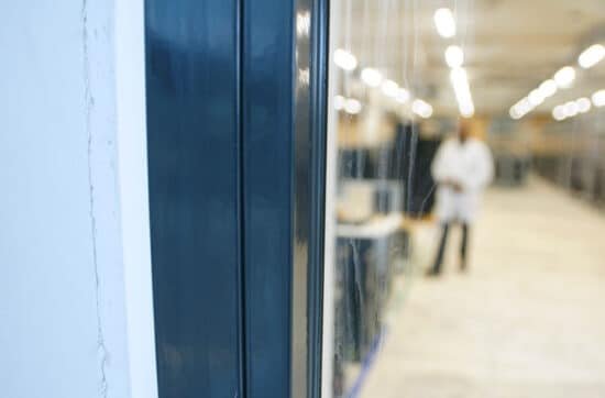 Brandwerende schuifdeur in een moderne werkomgeving met een technicus op de achtergrond, benadrukt de focus op brandveiligheid en innovatieve oplossingen van Grazy Brandwering.